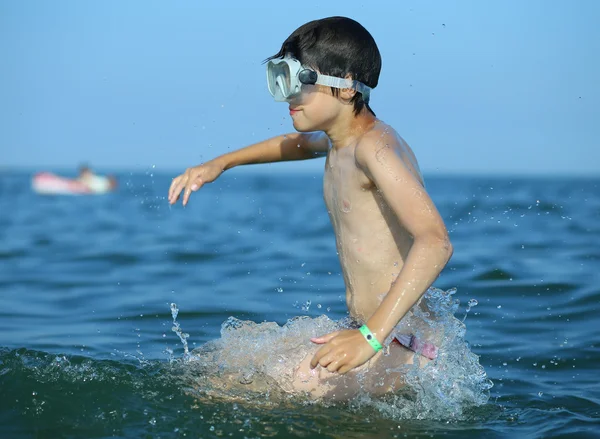Barn har roligt med mask i havet — Stockfoto