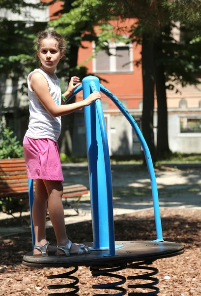 Girl is playing with a toy on the playground — Stock Photo, Image