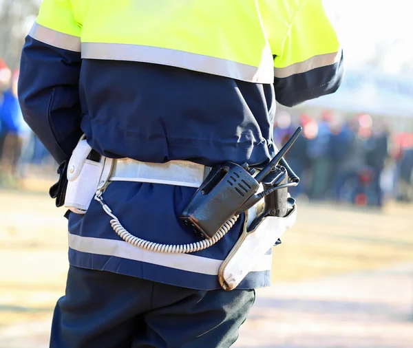 Polizist in Uniform mit Funksender und Waffe bei einem Einsatz — Stockfoto