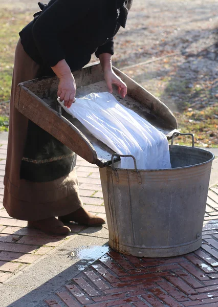 女人在木板上洗衣服, 旧的铁碗 — 图库照片