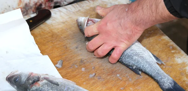 Handen van de visboer op de vismarkt tijdens het reinigen — Stockfoto