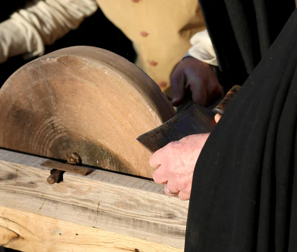 Knife sharpener sharpens his knife on the grinding wheel — Stock Photo, Image