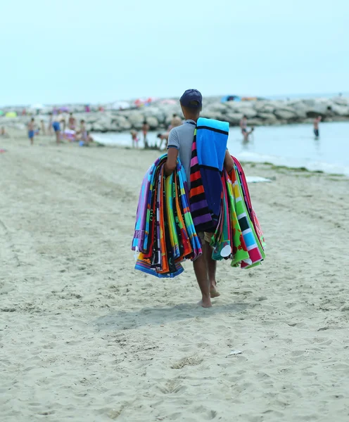 Pedlar of cloth and towels on the beach in summer — Stock Photo, Image