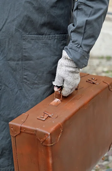 Poor emigrated with leather suitcase and the glove during travel — Stock Photo, Image