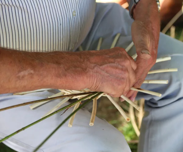 Grandes mains expert artisan tout en créant un panier — Photo