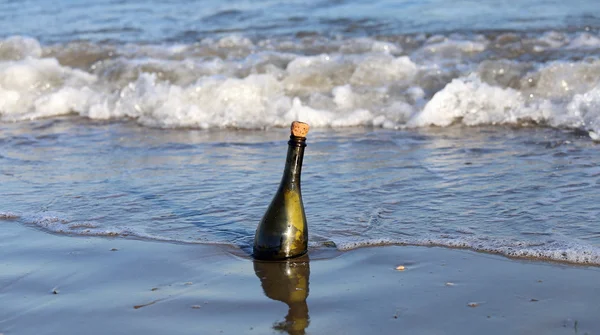 Бутылка на пляже с посланием — стоковое фото