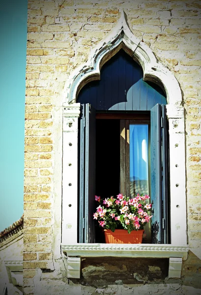 Flowered balcony with a window in the house and many flower pots — Stock Photo, Image