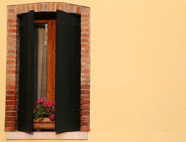 Blomstrande balkong med ett fönster i huset och många blomkrukor — Stockfoto