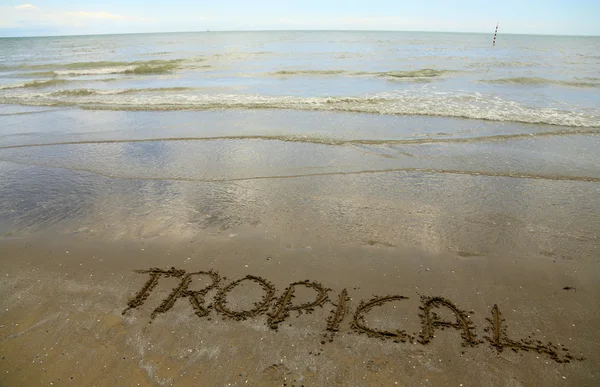 Tropical escrito en la arena de la playa —  Fotos de Stock