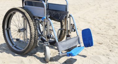 Wheelchair on the beach in summer clipart