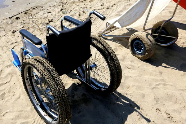 Две инвалидные коляски на пляжном песке — стоковое фото