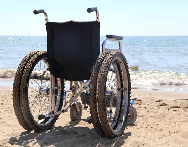 Sedia a rotelle sulla spiaggia in riva al mare in estate — Foto Stock