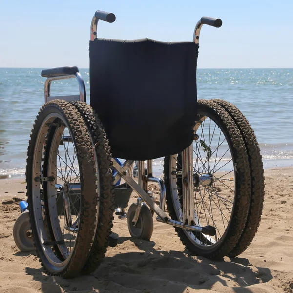 Silla de ruedas en la playa de arena — Foto de Stock