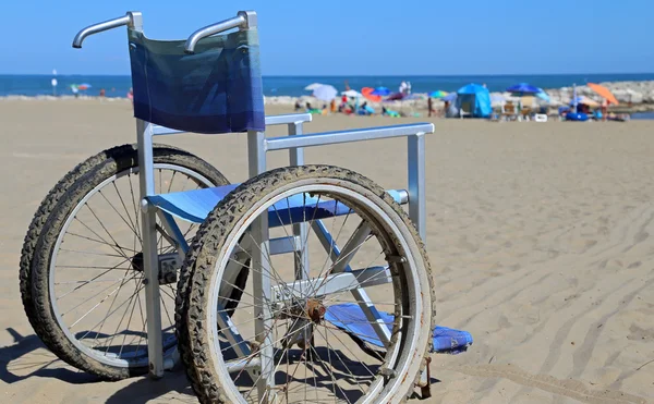 Silla de ruedas en la playa de arena — Foto de Stock