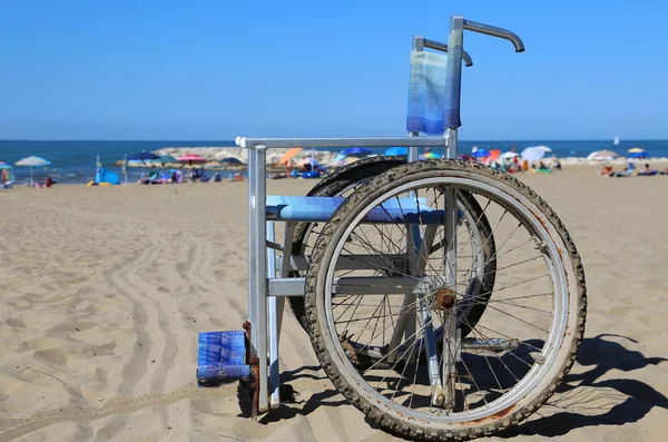 Rullstol på sanden på stranden — Stockfoto