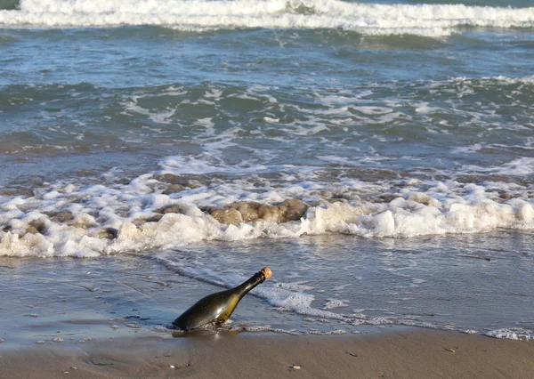 Бутылка на пляже с секретным посланием — стоковое фото