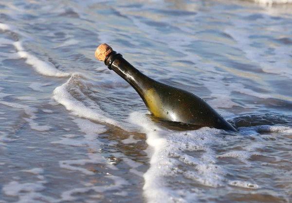Стеклянная бутылка на пляже с секретным сообщением — стоковое фото