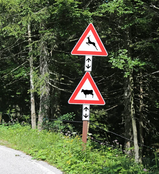 Znaki drogowe w pobliżu zwierzęta leśne uwagę przejście — Zdjęcie stockowe