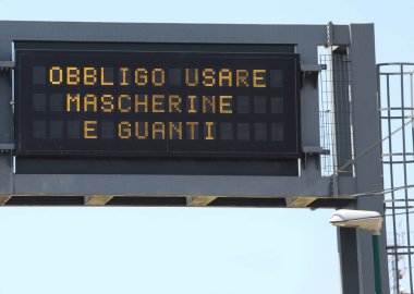 Pannel Yolu 'nda bulunan İtalyan metni cerrahi maske ve eldiven kullanma zorunluluğu anlamına geliyor.