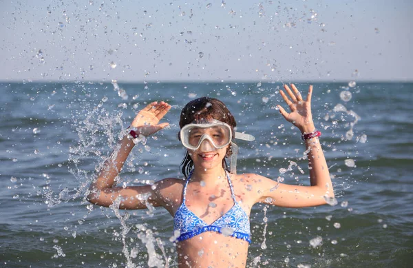 ダイビングマスクの少女は海の水を空気中に撒き散らし — ストック写真