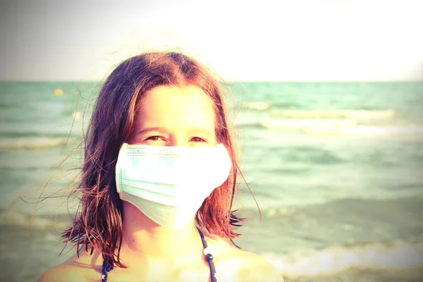 可愛いです女の子で外科用マスクと笑顔の目でヴィンテージ効果で海によって夏 — ストック写真