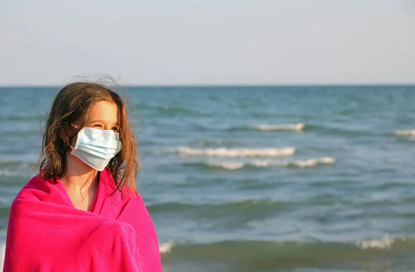バスローブと外科用マスクを着た少女がコロナウイルスで身を守るために — ストック写真