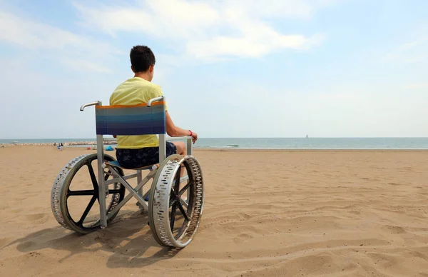 Młody Niepełnosprawny Chłopiec Wózku Inwalidzkim Piaszczystej Plaży Nad Morzem — Zdjęcie stockowe