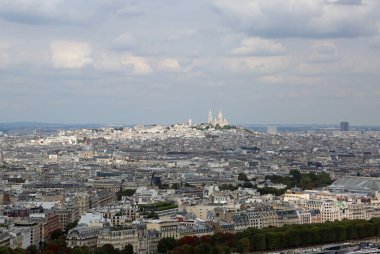 Paris manzarası ve MontMartre Kilisesi tepede ve Eyfel Kulesi 'nden birçok bulut.