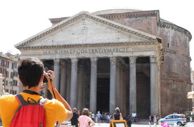 young tourist while taking a photograph at the ancient temple called Pantheon in the Italian capital Rome clipart