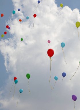 Büyük kutlamadan sonra mavi gökyüzünde renkli balonlar uçar.