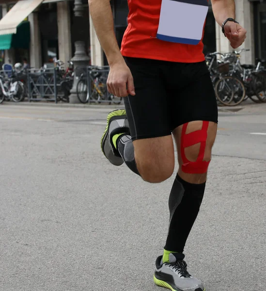 runner during the foot race with the calf bandage to prevent muscle strain