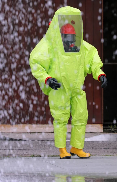 化学的及び生物学的危害から身を守るための黄色の保護服を着た者 — ストック写真