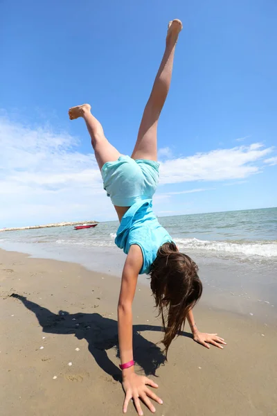 Młoda Wysportowana Dziewczyna Rękami Piasku Plaży Podczas Wykonywania Piruetu Nogami — Zdjęcie stockowe