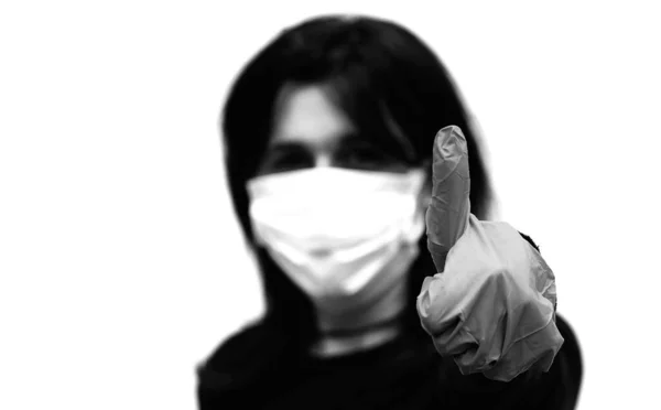 年轻女子的黑白照片 戴大拇指和外科口罩 以保护自己免受科洛纳病毒的侵害 — 图库照片