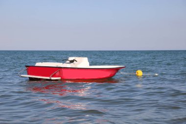 Yüzücüleri kurtarmak için denizin ortasında kırmızı bir tekne.