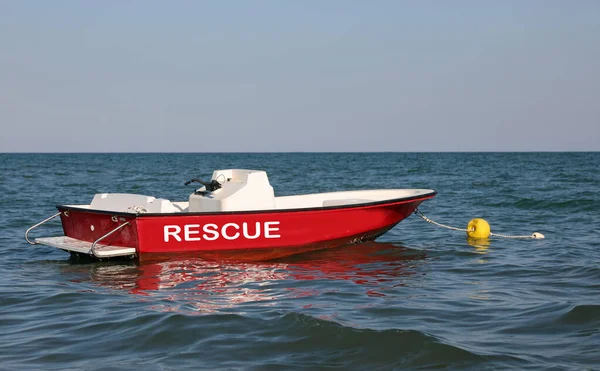 red motorboat in the middle of the sea to rescue swimmers with the large rescue text