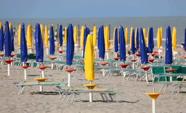 Strand Mit Geschlossenen Sonnenschirmen Niemand Auf Den Liegestühlen Wegen Der — Stockfoto