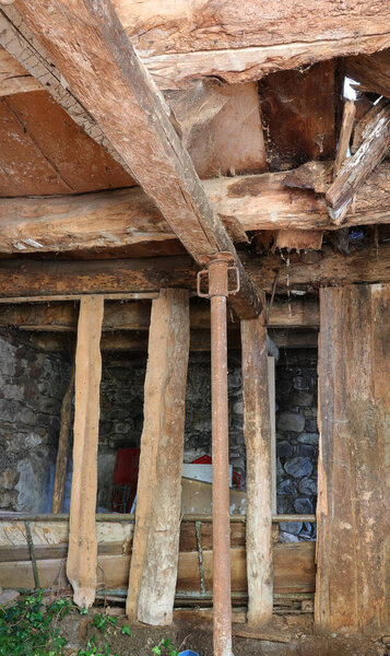 Wooden planks in an entrance to a crumbling mine building with supports to prevent collapse and disaster