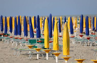 beach with closed umbrellas with no one above him lie down because of the lockdown in the Resort by the sea
