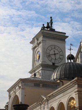 clock tower and two bronze statues above in the main square of the city of Udine in northern Italy