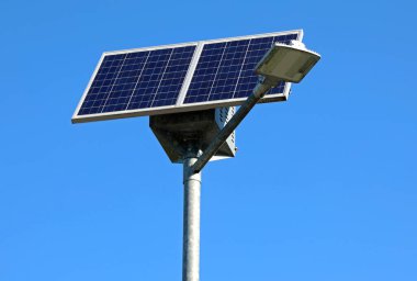 small solar panel that produces electricity to make the street lamp work without polluting