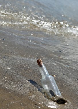 Kumsalda kıyıda mahsur kalmış bir şişe gizli bir mesaj ya da bir hazine haritası içeriyor olabilir.