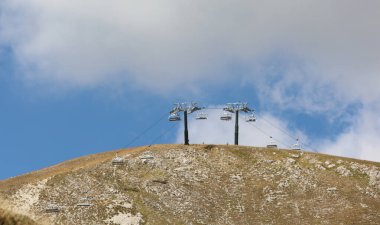 Yürüyüşçülerin turistlerini zahmetsizce dağın zirvesine taşımak için dağlardaki boş sandalyeler.