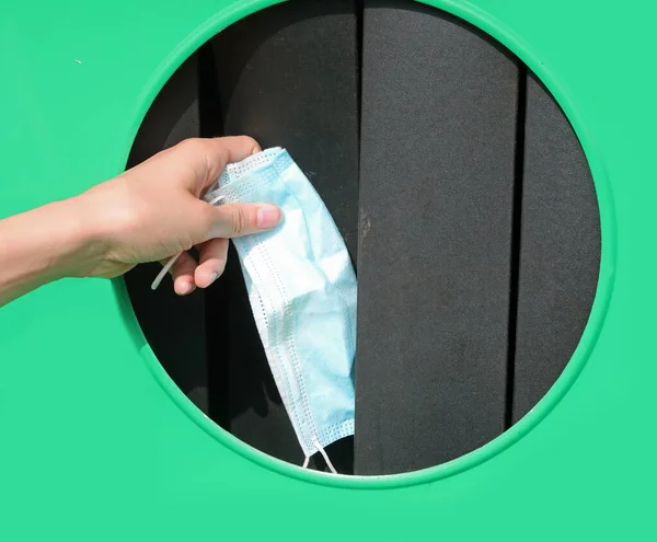 오염을 줄이기 재활용에 사용되는 수술용 마스크를 쓰레기통에 버리는 — 스톡 사진