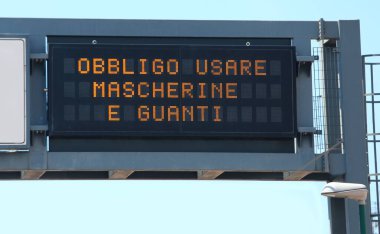 Kilitleme sırasında maske ve eldiven kullanma zorunluluğu anlamına gelen İtalyanca metni