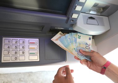 Euro banknotları ATM 'den çekildi ve PIN' e girdikten sonra el onları sayısal tuş takımı ile aldı.