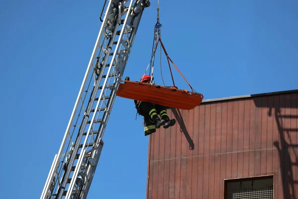 救难过程中 消防车空中平台上有担架的救火员 — 图库照片