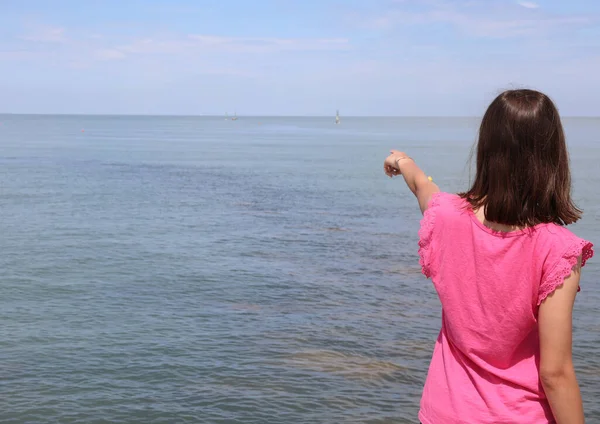 Młode Dziewczyny Koszuli Magenta Kolorowe Wskazując Punkt Horyzoncie Morza — Zdjęcie stockowe