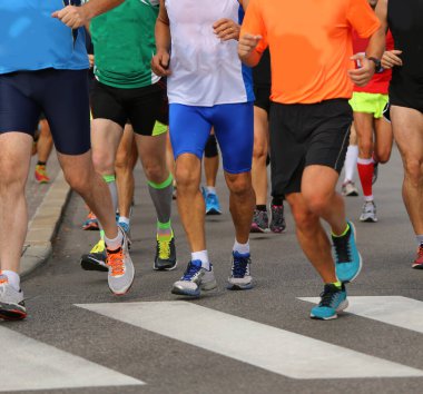 Maraton koşucularının bacakları ve ayakkabıları şehir yolunda yarışırken