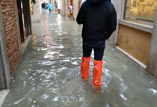 Személy Piros Vízhatlan Lábszárvédővel Séta Közben Utcán Teljesen Elárasztotta Dagály — Stock Fotó